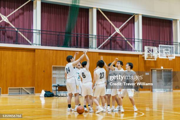 team of japanese female college basketball players celebrating - 体育館 ストックフォトと画像