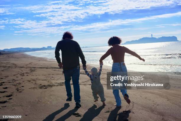 genuine surfer family running on local beach - eternal youth stock pictures, royalty-free photos & images