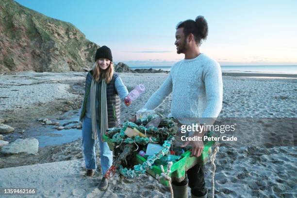 couple cleaning beach - south west england fotografías e imágenes de stock