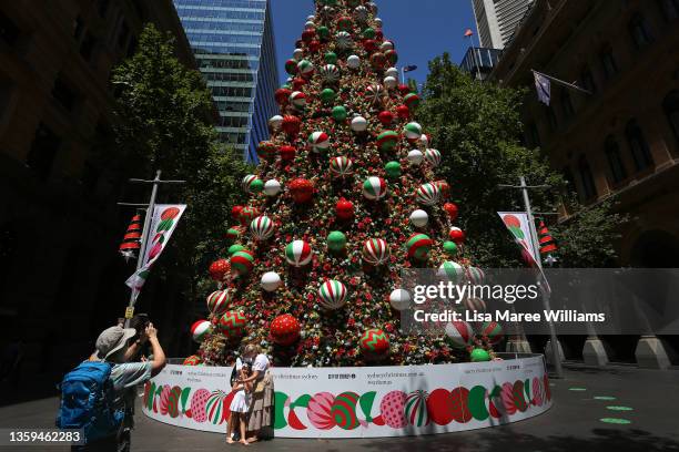 Sydneysiders take photos at a Christmas tree in Martin Place on December 17, 2021 in Sydney, Australia. New South Wales COVID-19 case numbers are on...