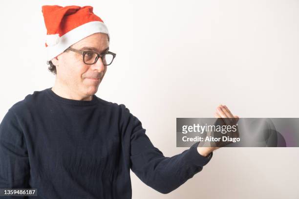 man in a santa hat tells someone to come forward. - beckoning stock pictures, royalty-free photos & images