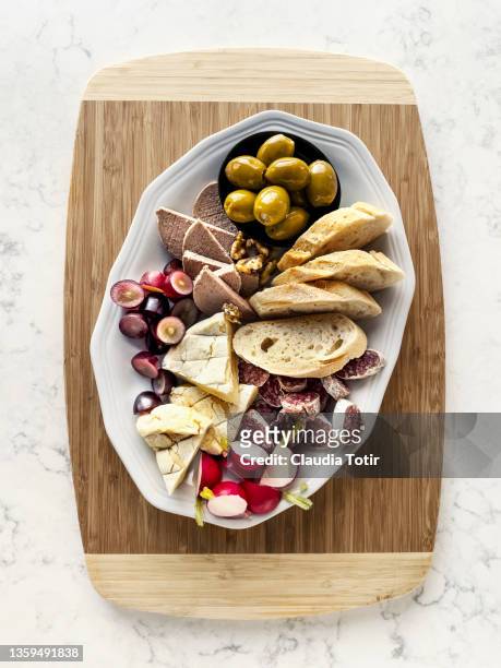 antipasto platter on wooden cutting board - charcuterie stockfoto's en -beelden