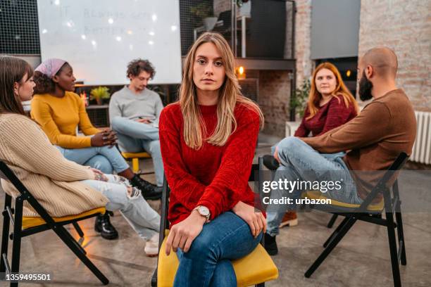 young woman at group therapy session - fobia imagens e fotografias de stock