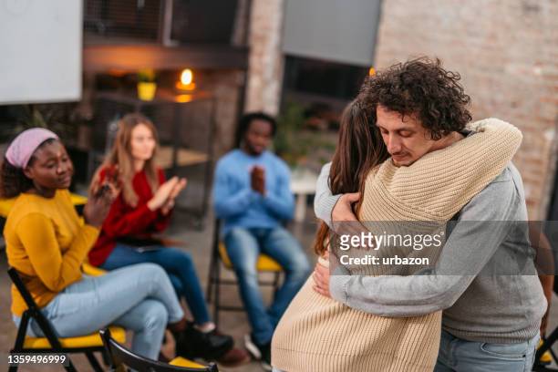 support group patients hug each other during the therapy session - drug addiction stock pictures, royalty-free photos & images