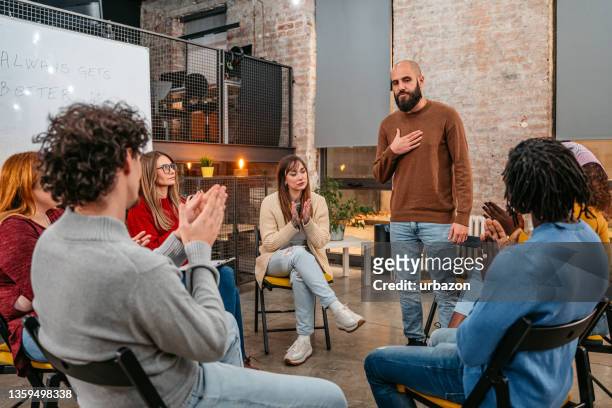 man talking to the other members of the therapy group - rehabilitation meeting stock pictures, royalty-free photos & images