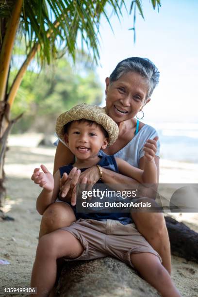 grandmother bonds with grandson on the beach - philippines stockfoto's en -beelden