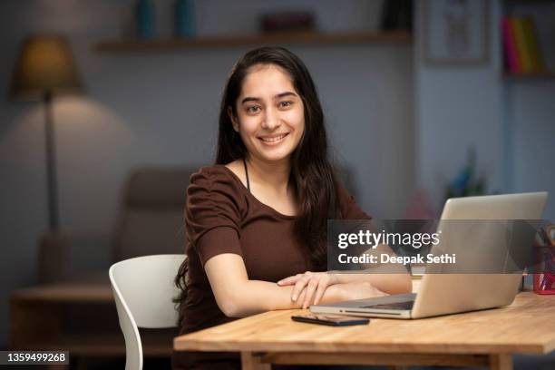 young woman working at home (using computer) stock photo - indian ethnicity stockfoto's en -beelden