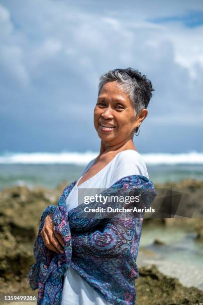 porträt einer älteren frau am strand - filipino woman stock-fotos und bilder