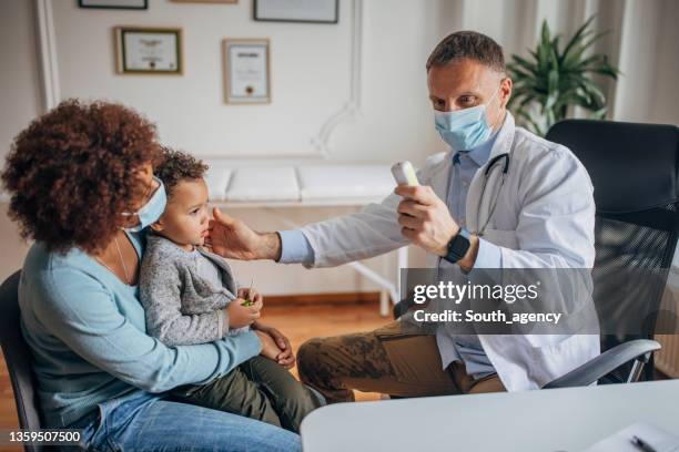 little boy at the doctor - infrared thermometer stock pictures, royalty-free photos & images