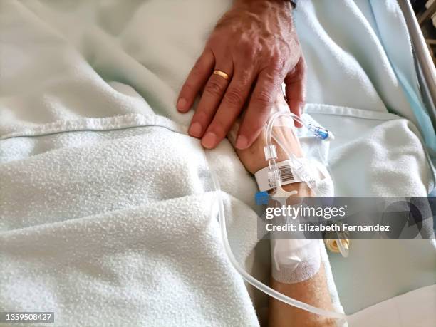 man holding hand of woman in hospital, close-up - iv drip womans hand stock-fotos und bilder