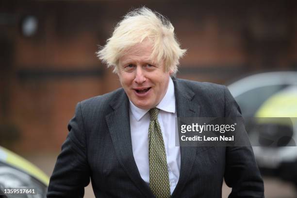 Britain's Prime Minster Boris Johnson speaks with police officers as he makes a constituency visit to Uxbridge police station on December 17, 2021 in...