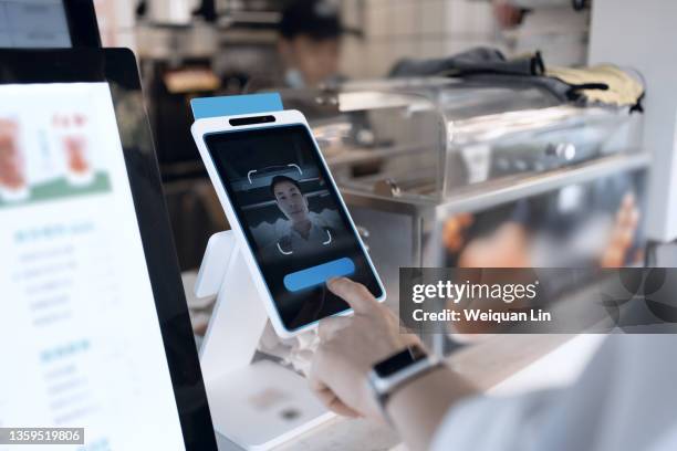 asian man is using facial recognition for payment - digital shopping stockfoto's en -beelden