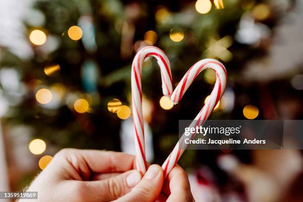 candy cane heart with christmas tree lights bokeh - zuckerstange stock-fotos und bilder