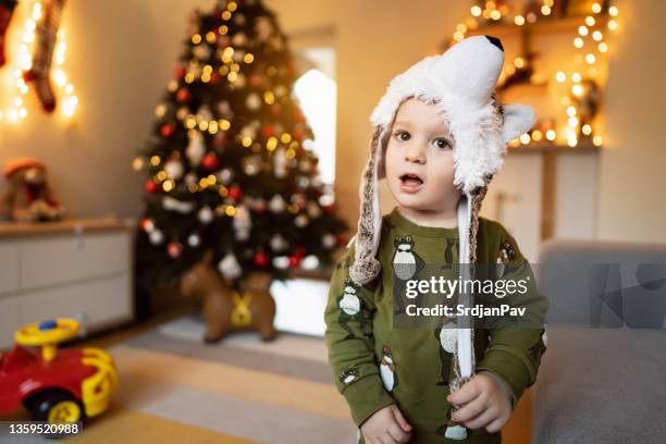 cute toddler boy wearing pajamas and winter hat in wolf shape - stocking tops stock pictures, royalty-free photos & images