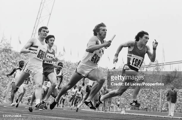 British sprinter David Dear receives the baton from teammate Don Halliday in the 2nd baton change of heat four of the Men's 4 x 100 metres relay...