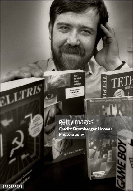 Portrait of Russian American computer engineer and video game designer Alexey Pajitnov, as he poses with an assortment of books about his game,...