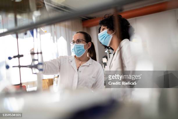 two female chemists analyze medical sample - bióloga imagens e fotografias de stock