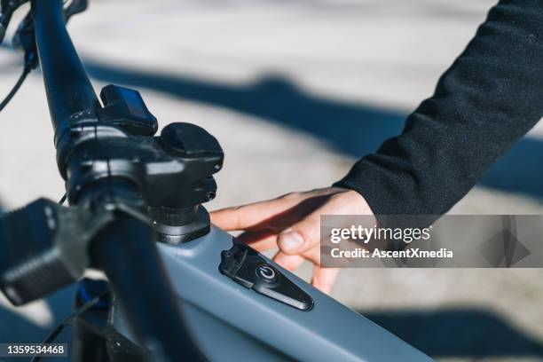 close up of young woman turning her e-bike on - electric bike stockfoto's en -beelden