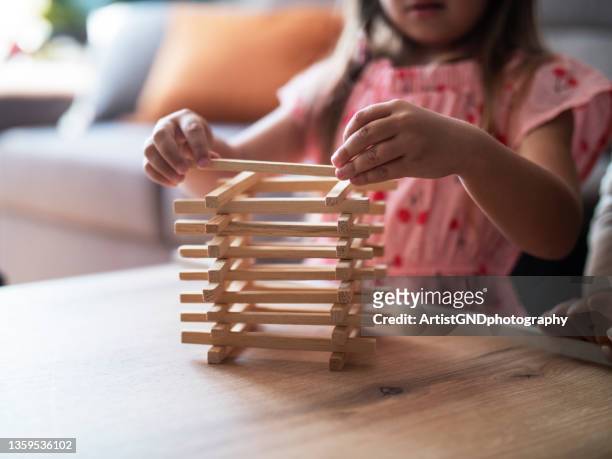 little girl playing jenga at home - jenga stockfoto's en -beelden
