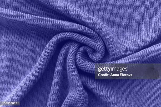 texture of a knitted violet sweater folded in a swirling pattern. flat lay style, close-up. demonstrating very peri - color of 2022 year. - purple shirt - fotografias e filmes do acervo