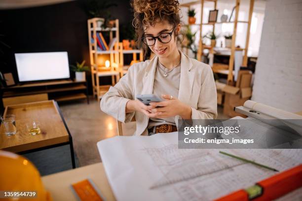 woman uses a mobile phone - small office building stock pictures, royalty-free photos & images