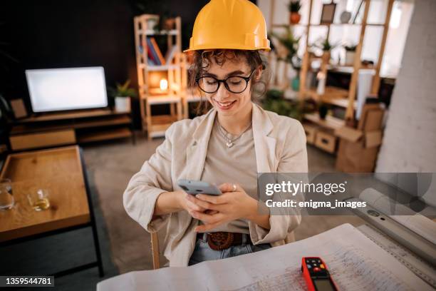 woman uses a mobile phone - small office building stock pictures, royalty-free photos & images