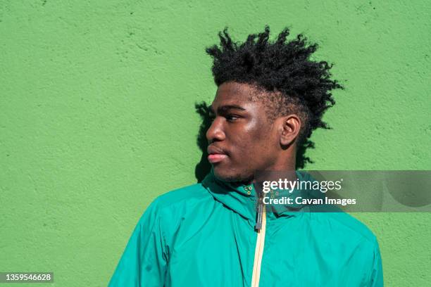 portrait of serious black boy on green wall background. - modern boy hipster stock-fotos und bilder