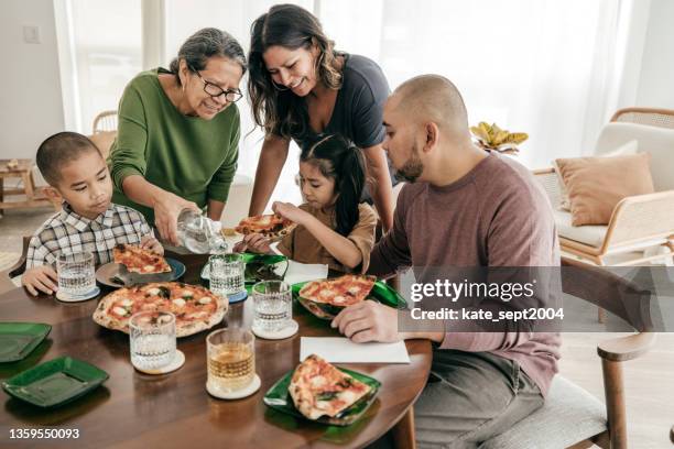 multiethnische familie mit pizza zum mittagessen - philippinischer-abstammung stock-fotos und bilder