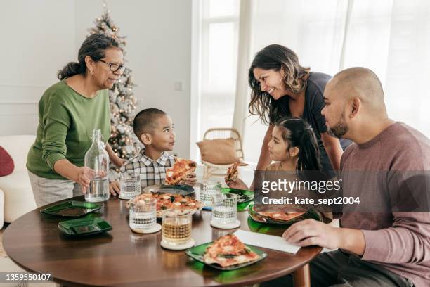 familia multiétnica comiendo pizza para el almuerzo - filipino family eating fotografías e imágenes de stock