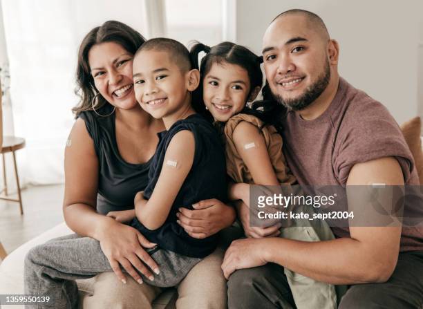 retrato familiar vacunado: cuatro personas con vacuna - esparadrapo fotografías e imágenes de stock