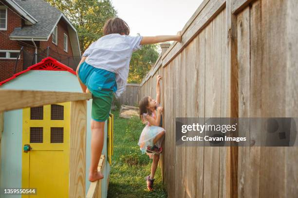 two children climb and play together in backyard - columbus ohio house stock pictures, royalty-free photos & images