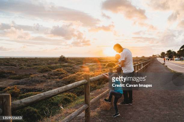 father and children watching sunset at fuerteventura beach - family sports centre laughing stock pictures, royalty-free photos & images
