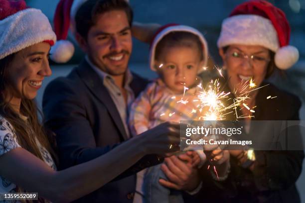 latin family celebrating christmas having fun wearing santa claus hats - hot latin nights stock pictures, royalty-free photos & images