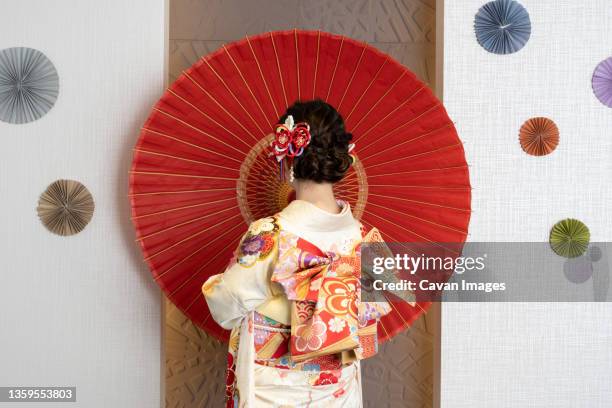 female adult in kimono with an umbrella spread - 芸者 ストックフォトと画像