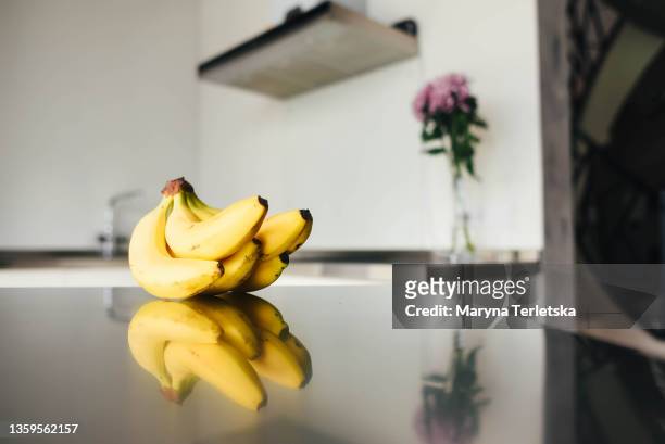 bananas lie on the table against the background of modern kitchen. - banana ストックフォトと画像