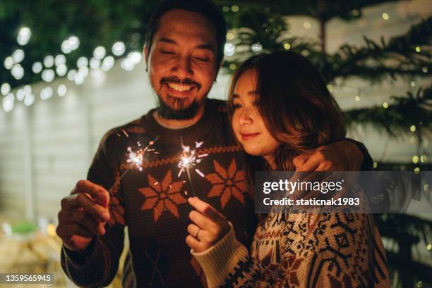 amici asiatici con sparklers che si godono la festa all'aperto - christmas couple foto e immagini stock