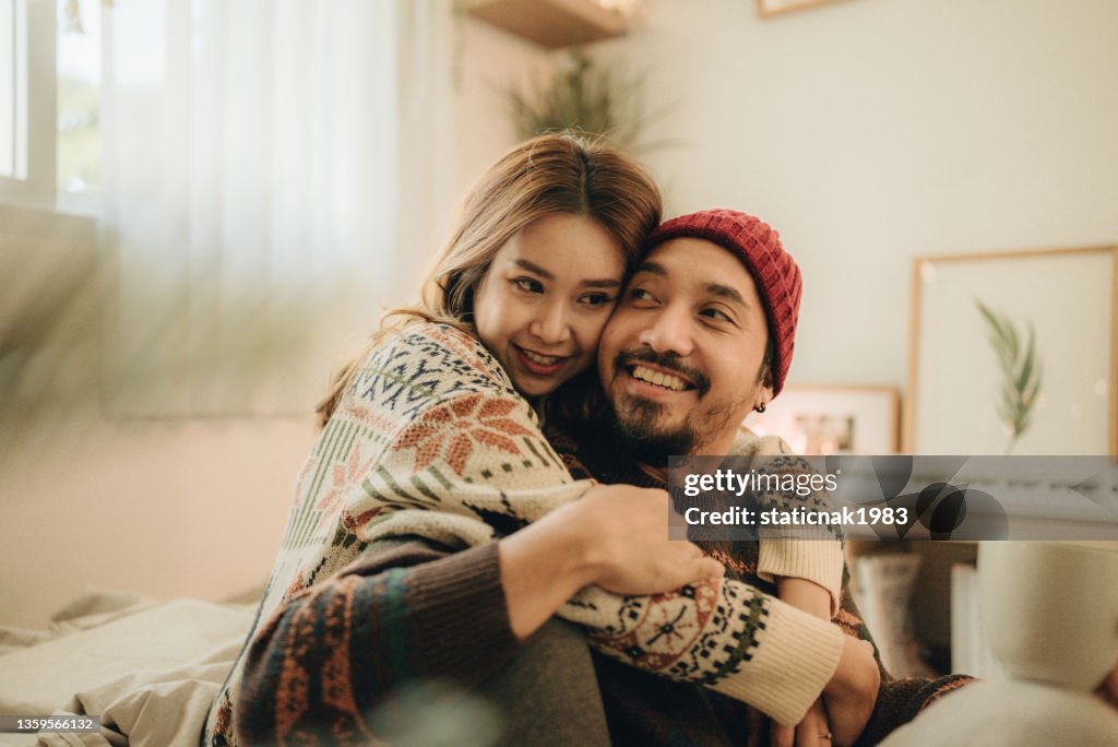 Happy young couple relaxing talking laughing drinking coffee tea