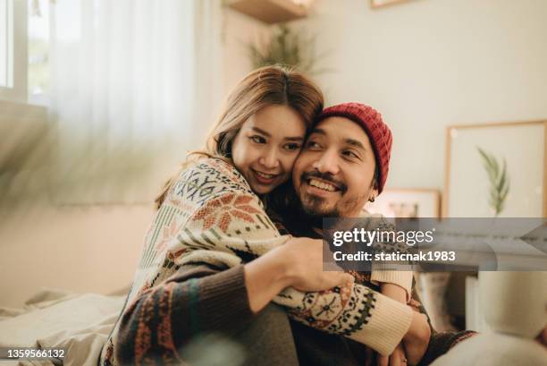 happy young couple relaxing talking laughing drinking coffee tea - couple laughing hugging stockfoto's en -beelden
