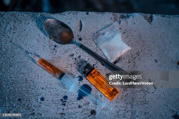 jeringa de drogas, heroína en polvo en paquete, cuchara y encendedor - anfetaminas fotografías e imágenes de stock