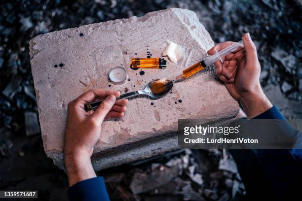 drogadicto preparando su dosis de heroína - crack cocaine fotografías e imágenes de stock
