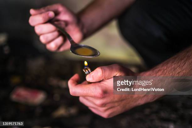 man preparing heroin for injection - crack spoon stock pictures, royalty-free photos & images