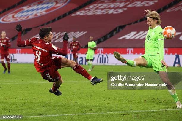 Robert Lewandowski of Muenchen scores his team's fourth goal against Sebastiaan Bornauw of Wolfsburg during the Bundesliga match between FC Bayern...