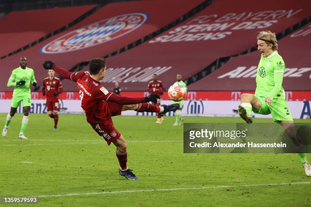Robert Lewandowski of Muenchen scores his team's fourth goal against Sebastiaan Bornauw of Wolfsburg during the Bundesliga match between FC Bayern...