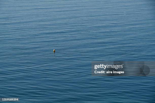 yellow buoy floating in the ocean - float photos et images de collection