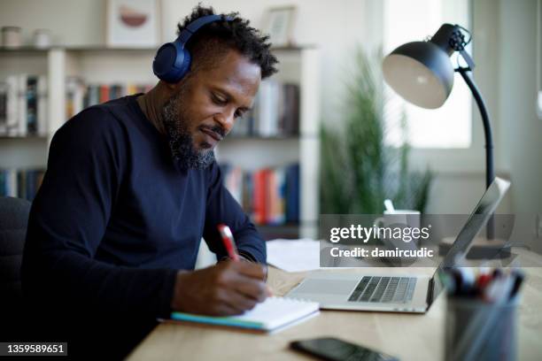 man with bluetooth headphones working at home office - virtual author stock pictures, royalty-free photos & images