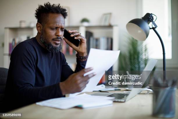 worried man talking on the phone while working from home - no idea stock pictures, royalty-free photos & images