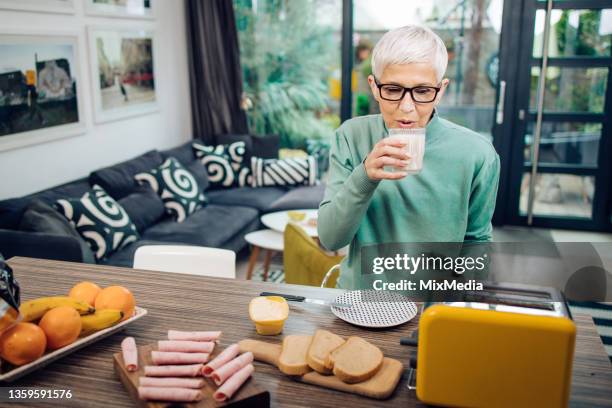senior woman having a breakfast at home - old toaster stock pictures, royalty-free photos & images