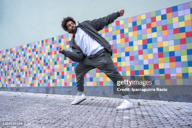 black ethnic man with afro hair urban dancer, performing a modern dance on a colorful background, copy space - colour street dance stock pictures, royalty-free photos & images