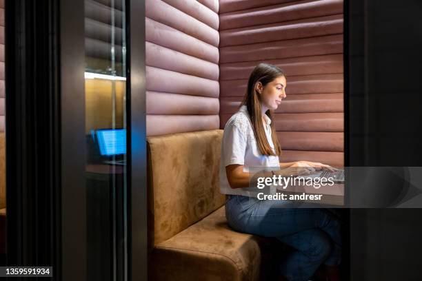 business woman working in an isolated booth at the office - telephone box stock pictures, royalty-free photos & images