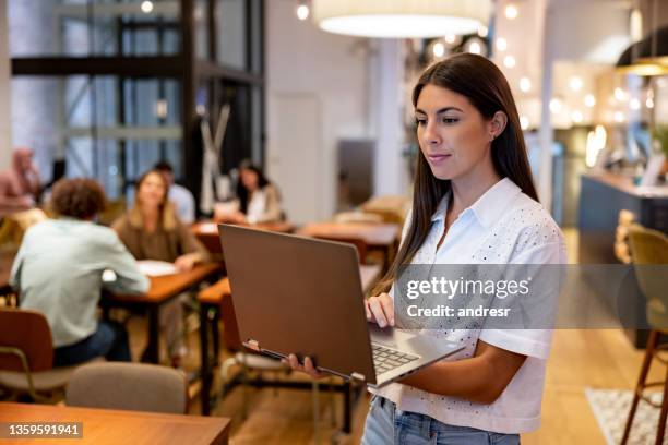 business woman using a laptop while working at a coworking office - coworking spaces stock pictures, royalty-free photos & images